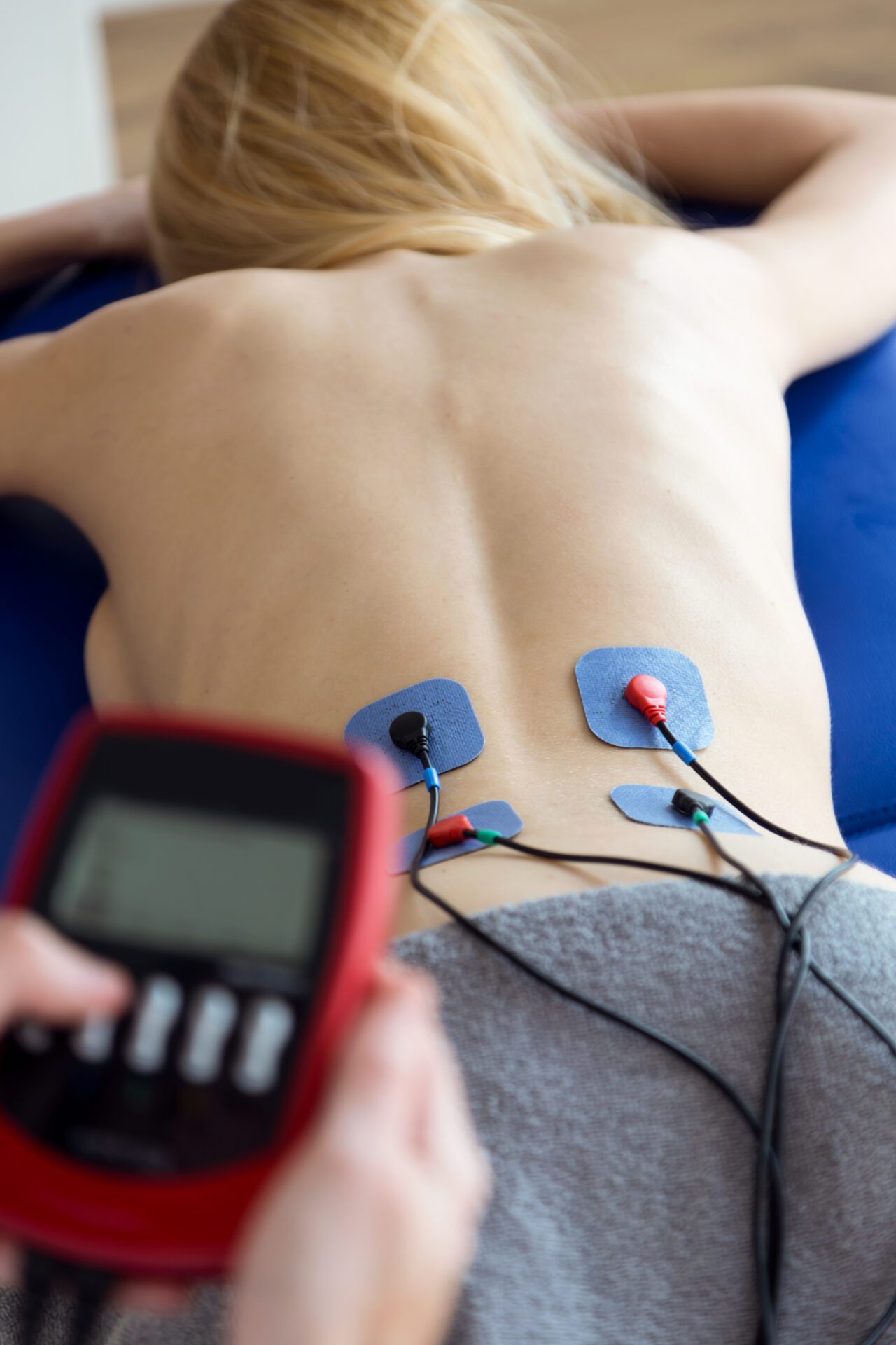 Young physioterapist applying electro stimulation in physical th You, Naturally Better